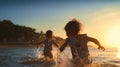 happy two children ,small boys on sunset sea run and play on beach and in sea water Royalty Free Stock Photo