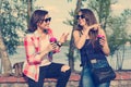Happy two female friends drinking coffee and having fun. Background nature, park, river. Urban lifestyle and friendship concept Royalty Free Stock Photo
