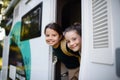 Happy two little girls looking out of caravan and smiling to camera. Royalty Free Stock Photo