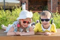 Happy two small children, a boy and a girl in sunglasses, headphones, listening to music, singing a song, laughing Royalty Free Stock Photo