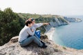 Happy two women friends sitting and looking at beautiful sea landscape on top of the mountain. Friendship and nature concept Royalty Free Stock Photo
