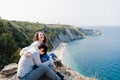 Happy two women friends sitting and looking at beautiful sea landscape on top of the mountain. Friendship and nature concept Royalty Free Stock Photo