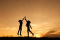 Happy of two women jumping and sunset silhouette Royalty Free Stock Photo