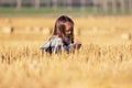 Happy two year old girl walking in a summer harvested field