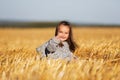 Happy two year old girl walking in summer harvested field
