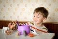 Happy two years old toddler baby boy child play toys and eat his lunch. Kid playing with educational toys while eating Royalty Free Stock Photo