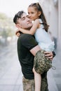 Happy Ukrainian soldier returning from the war meets his little daughter and embraces her