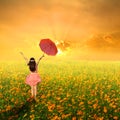 Happy umbrella woman jumping in flower garden and sunset Royalty Free Stock Photo