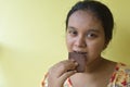 Happy unformal woman eating home made chocolate standing the living room at home