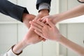 Happy united business team joins hands as a sign of business teamwork. stacking hands celebrating victory in office. concept of