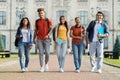 Happy university students walking together on campus, laughing and looking at camera Royalty Free Stock Photo