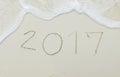 Happy Upcoming New Year 2017 Start with Fresh Concept, Numbers 2017 Handwritten on White Sea Sand Tropical Beach with Ripple Royalty Free Stock Photo