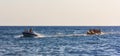 Happy vacationers tourists ride an inflatable banana in the sea in summer