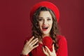 excited stylish woman in dress and beret on background