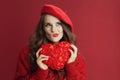 pensive trendy woman in red sweater and beret with red heart Royalty Free Stock Photo