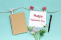 Happy Valentine`s card with blank brown notebook and heart paper clip on blue background Royalty Free Stock Photo