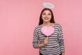 Happy Valentine`s day! Angelic woman with holy nimbus holding pink paper heart and smiling to camera Royalty Free Stock Photo