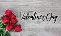 Happy Valentine`s Day Calligraphy Font Text with Beautiful Red Rose Flowers in Corner Over Light Wood Background Royalty Free Stock Photo