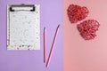 A notebook with a pen and pencil for writing a greeting text and two rattan hearts Royalty Free Stock Photo
