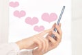 Happy Valentine`s day, girl sends love hearts from smartphone