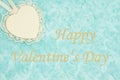 Happy Valentine`s Day greeting with a heart with lace on pale teal rose plush fabric