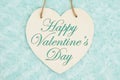 Happy Valentine`s Day message on wood heart shaped plaque with teal plush fabric