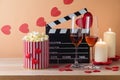 Happy Valentine\'s day and romantic movie concept with movie clapper board, heart shapes, wine and popcorn on wooden table Royalty Free Stock Photo