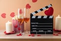 Happy Valentine\'s day and romantic movie concept with movie clapper board, heart shapes, wine and popcorn on wooden table Royalty Free Stock Photo