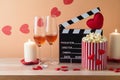 Happy Valentine\'s day and romantic movie concept with movie clapper board, heart shapes, wine and popcorn on wooden table Royalty Free Stock Photo