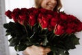 Happy Valentine's Day. smiling young woman holding a big luxury bouquet of red roses flowers. Celebration of Royalty Free Stock Photo