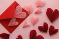 Happy Valentine`s day! Stylish pink hearts and red envelope flat lay on pink paper background. Modern Valentines day composition.