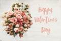 Happy Valentine`s Day text sign on pink roses bouquet on white background, top view. Valentines day floral greeting card Royalty Free Stock Photo