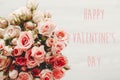 Happy Valentine`s Day text sign on pink roses bouquet on white background, top view. Valentines day floral greeting card Royalty Free Stock Photo