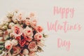 Happy Valentine`s Day text sign on pink roses bouquet on white background, top view. Valentines day floral greeting card Royalty Free Stock Photo