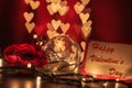 Happy Valentine`s day writing on card with light bulb and rose on heart shaped bokeh lights Royalty Free Stock Photo