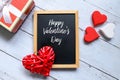 Happy Valentine`s day written on a blackboard with red and white wooden heart handcraft and a box Royalty Free Stock Photo