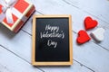 Happy Valentine`s day written on a chalkboard with wooden handraft heart and box Royalty Free Stock Photo