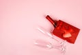 Happy Valentine's Day flatlay. Top view bottle of rose champagne in gift box, hearts, glasses on soft pink background Royalty Free Stock Photo