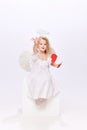 Happy Valentine& x27;s Day. Little baby cupid, beautiful girl in white dress holding paper heart isolated over white