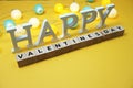 Happy Valentines Day alphabet letter with LED cotton balls on yellow background Royalty Free Stock Photo
