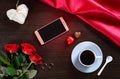 Happy Valentines Day background with wedding rings, rose flowers, smartphone, cup of coffee and chocolate candy Royalty Free Stock Photo