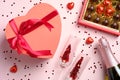 Happy Valentines day concept. Flat lay romantic composition with heart shaped box decorated red ribbon bow, sweets, champagne and Royalty Free Stock Photo