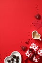 Happy Valentines day concept. Top view table with gift box, heart shaped candy, coffee cup, envelope, confetti on red background. Royalty Free Stock Photo