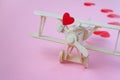 Happy Valentines day. wooden children`s plane on a pink background with red heart, and garland in the shape of a heart Royalty Free Stock Photo