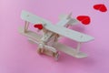 Happy Valentines day. wooden children`s plane on a pink background with red heart, and garland in the shape of a heart Royalty Free Stock Photo