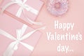 Happy Valentines Day greeting card with pink gift box and sweet donut, ribbon, bow flat lay on living coral color background.