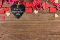 Happy Valentines Day heart shaped chalkboard tag with border against rustic wood