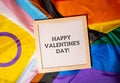 HAPPY VALENTINES DAY text frame on Rainbow LGBTQIA flag made from silk material. Symbol of LGBTQ pride month. Equal Royalty Free Stock Photo