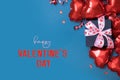 Happy Valentines Day text with gift box and red heart shape baloons on blue background. Valentines Day greeting card Royalty Free Stock Photo