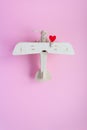 Happy Valentines day. wooden children`s plane on a pink background with red heart Royalty Free Stock Photo